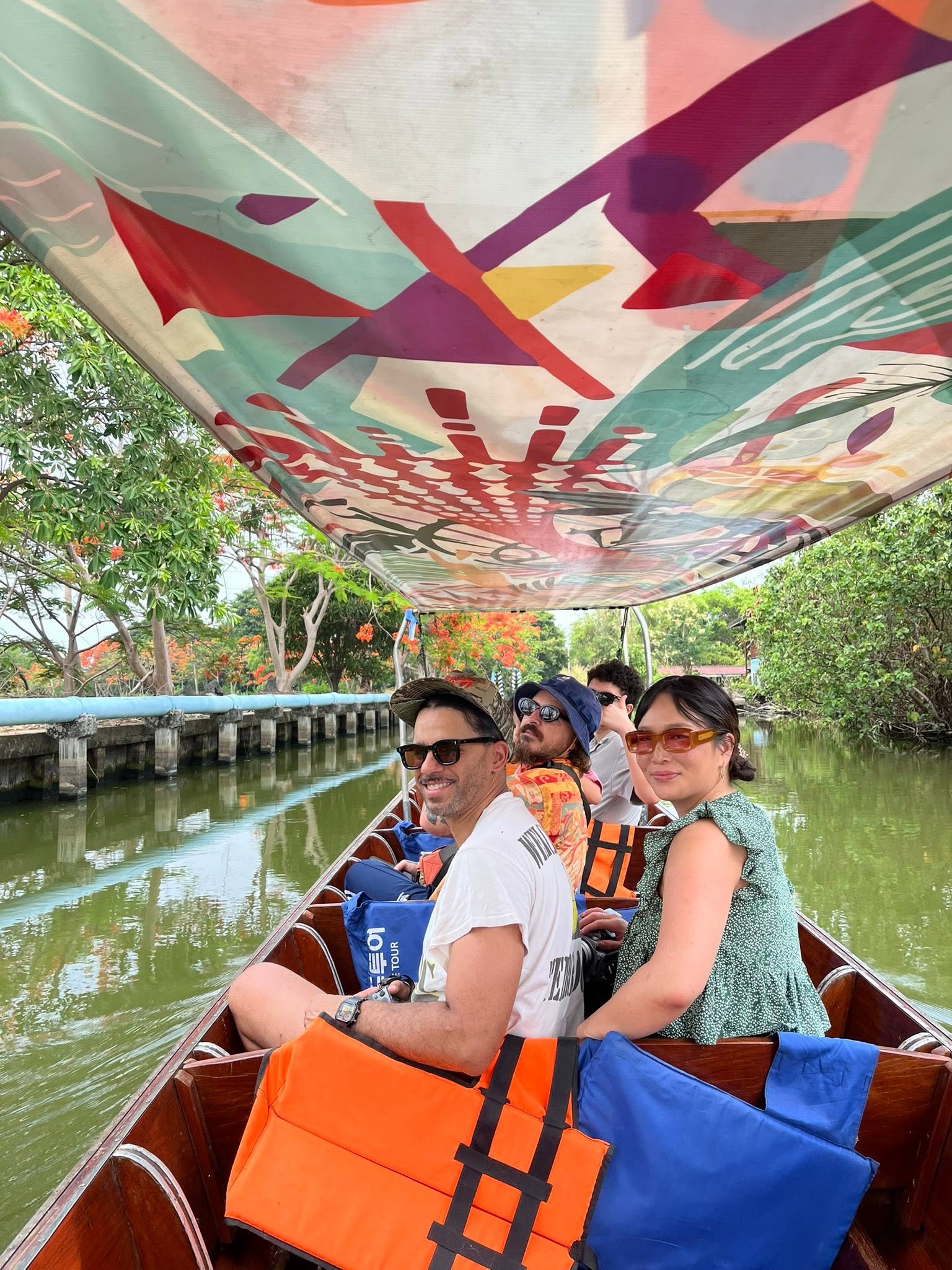 Travelers riding a longtail boat together along a Bangkok canal